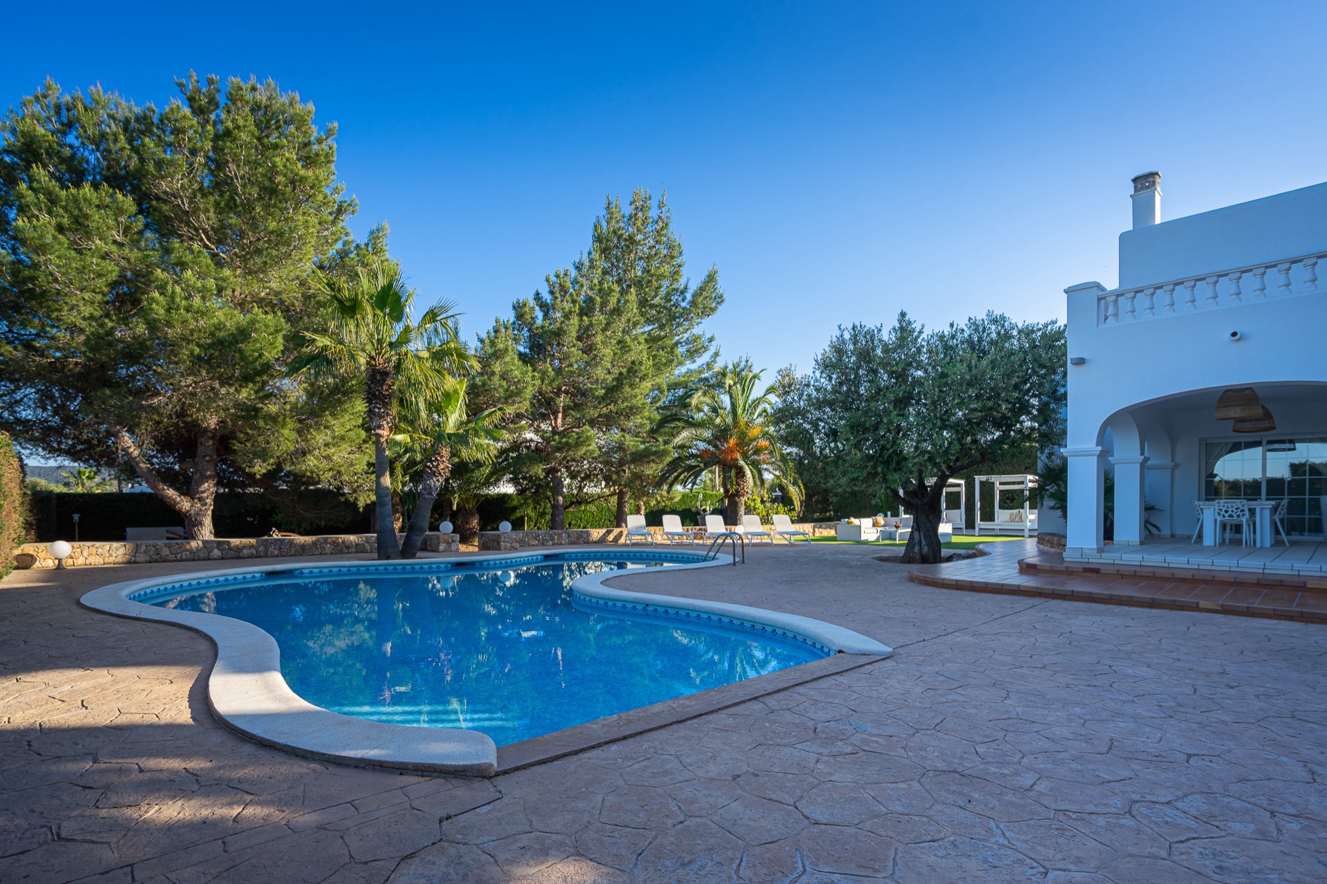 Terraza exterior de Villa Oasis Ibiza con tumbonas y vistas al campo ibicenco